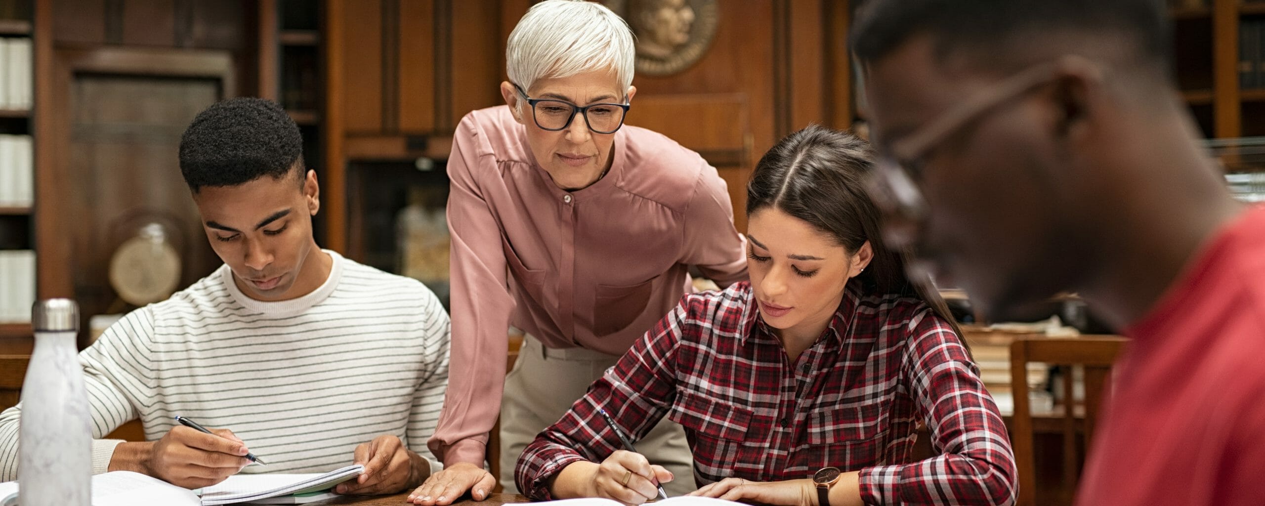 University students studying with teacher