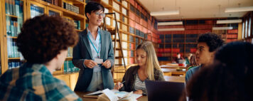 Librarian talking to students in the library